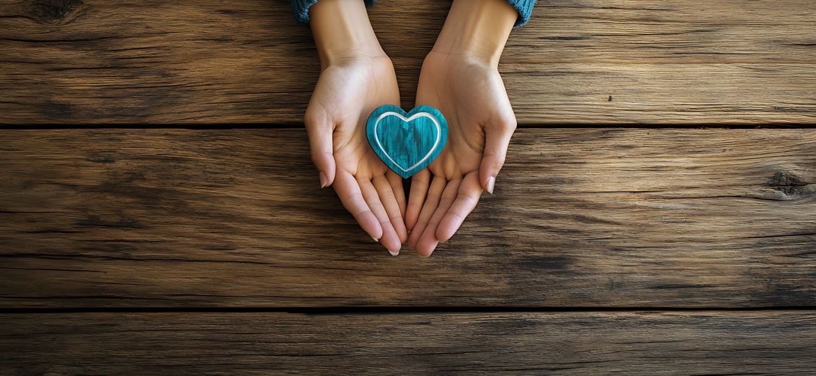 A motivational International Volunteer Day composition with a pair of open hands and a heart shaped emblem resting on a wooden table, macro shot, Minimalist style